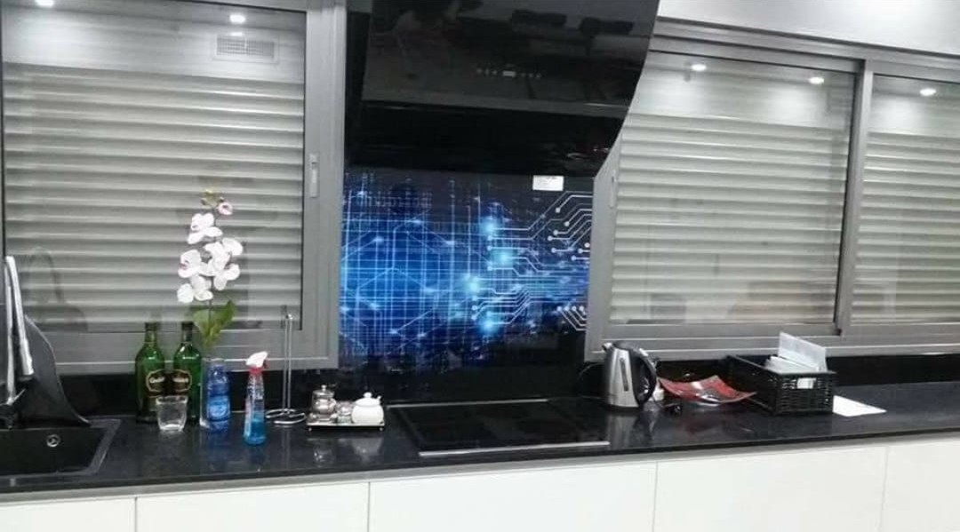 A blue patterned kitchen backsplash between metallic cabinets.